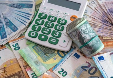 kalkulator oraz pieniądze w różnych walutach na stole